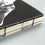 「コデックス装」は『糸綴じの背をそのまま見せる』製本方法です。背表紙がないため、本文を180度開くことができます。機能性に加え、あえて黒い糸で綴じることで、糸もデザインの一部として、冊子全体の雰囲気を作り出しています。